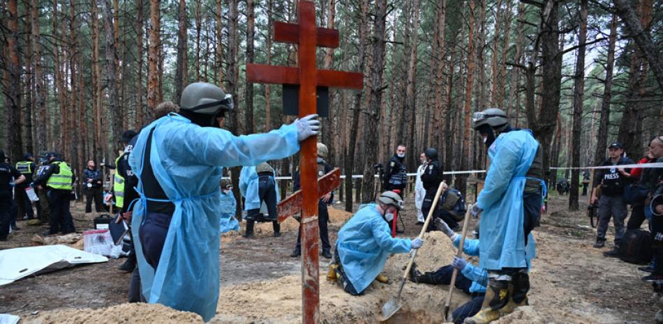 Los técnicos forenses cavan una tumba en un bosque en las afueras de Izyum. afp/
