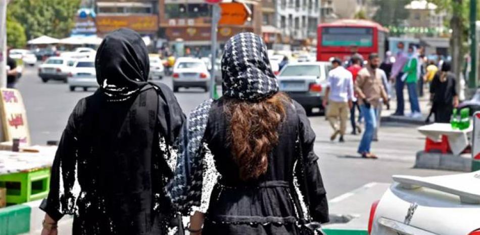 Dos mujeres caminan por calles de la capital iraní. afp/