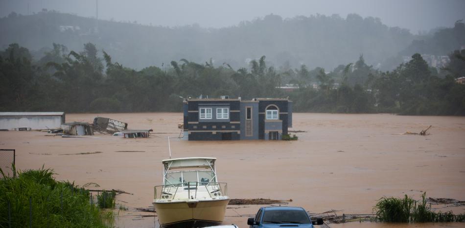 Una casa está sumergida en las inundaciones causadas por el huracán Fiona en Cayey, Puerto Rico, el domingo 18 de septiembre de 2022. Según las autoridades, tres personas estaban dentro de la casa y se informó que fueron rescatadas. (Foto AP/Stephanie Rojas)
