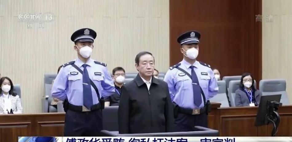 En esta imagen, tomada de imágenes emitidas por la televisora china CCTV, el exministro de Justicia Fu Zhenghua es escoltado por la policía judicial durante una vista de sentencia, en Changchun, en la provincia nororiental china de Jilin, el 22 de septiembre de 2022. Foto: CCTV/AP.