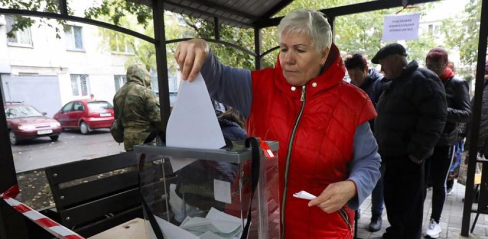 Una mujer deposita su voto en una casilla electoral móvil ayer viernes, en Mariúpol, en Donetsk, controlada por separatistas respaldados por Rusia.  ap