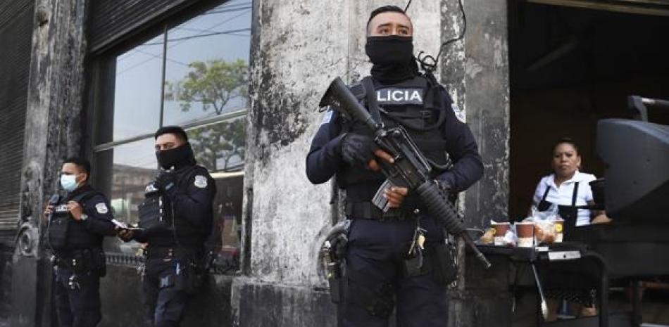 Policías fuertemente armados vigilan las calles como parte de un estado de excepción en San Salvador. El foro criticó los planes reeleccionistas de Nayib Bukele.  ap
