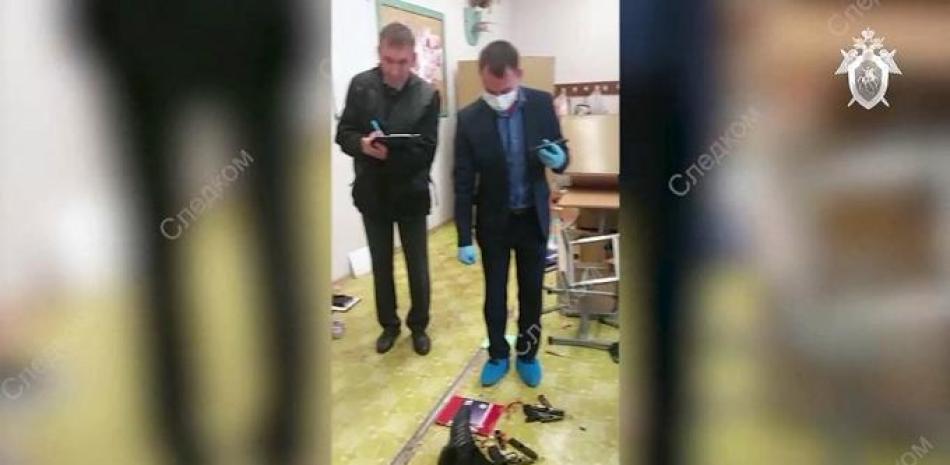 Esta captura de pantalla tomada de un video publicado por el Comité de Investigación de Rusia el 26 de septiembre de 2022 muestra a los investigadores trabajando junto al cuerpo de un pistolero en la escuela No88 en Izhevsk. El número de muertos aumentó a 13 personas, incluidos siete niños, después de un tiroteo en una escuela en la ciudad de Izhevsk, en el centro de Rusia, dijeron los investigadores el 26 de septiembre.
Comité de Investigación de Rusia / AFP