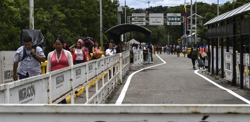 Ciudadanos venezolanos caminan por el puente internacional entre Colombia y Venezuela en San Antonio del Táchira, Venezuela, el 25 de septiembre de 2022. Venezuela y Colombia abrirán sus fronteras terrestres y aéreas el 26 de septiembre después de haber sido cerradas parcialmente en 2015 y completamente cerradas en 2019 después la ruptura de las relaciones diplomáticas entre los dos países. Yuri CORTEZ / AFP