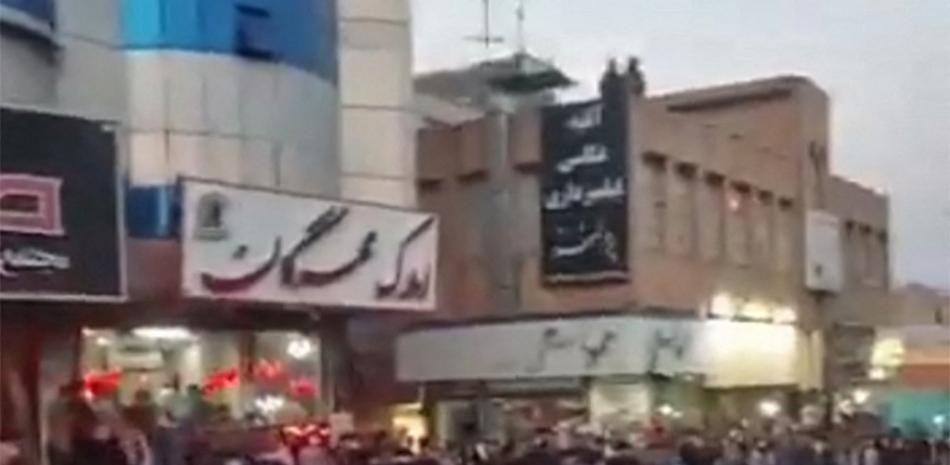 Esta captura tomada de un video del 21 de septiembre de 2022 muestra a mujeres iraníes quitándose el hiyab durante una manifestación en la ciudad de Saveh. Foto: AFP.