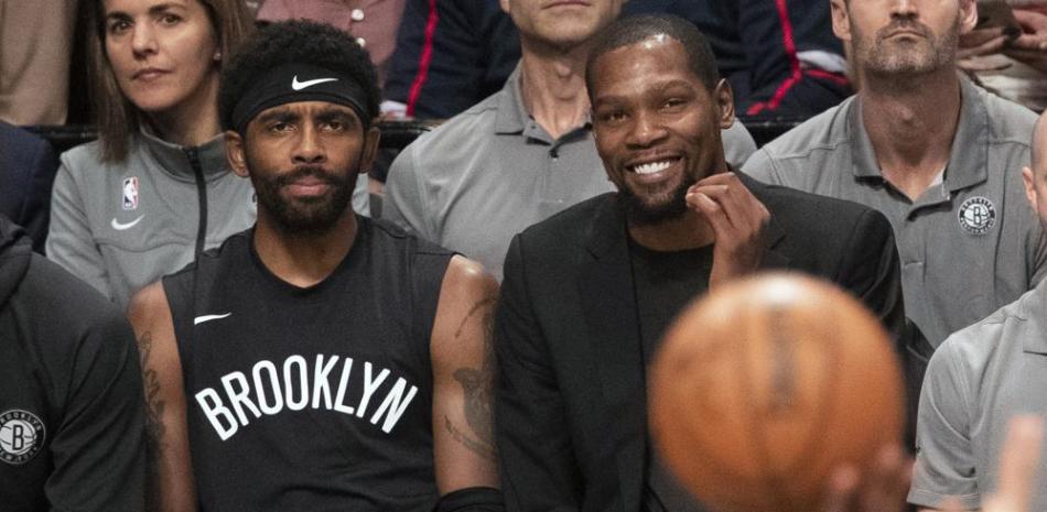 Foto del 1 de noviembre del 2019, Kyrie Irving y Kevin Durant de los Nets de Brooklyn observan desde la banca el encuentro ante los Rockets de Houston en Nueva York.