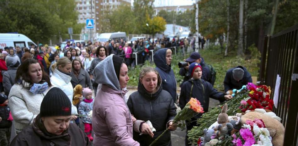 Personas se reúnen para colocar flores, juguetes y encender veladoras por las víctimas del ataque registrado en la Escuela 88 en Izhevsk ap
