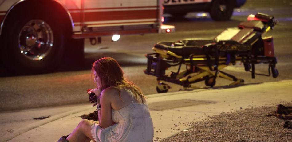 Una mujer sentada en una acera el 2 de octubre de 2017 en el lugar de un tiroteo masivo ocurrido en un festival musical el 1 de octubre en el que muieron 58 personas y cientos resultaron heridas en Las Vegas. (Foto AP/John Locher, archivo).
