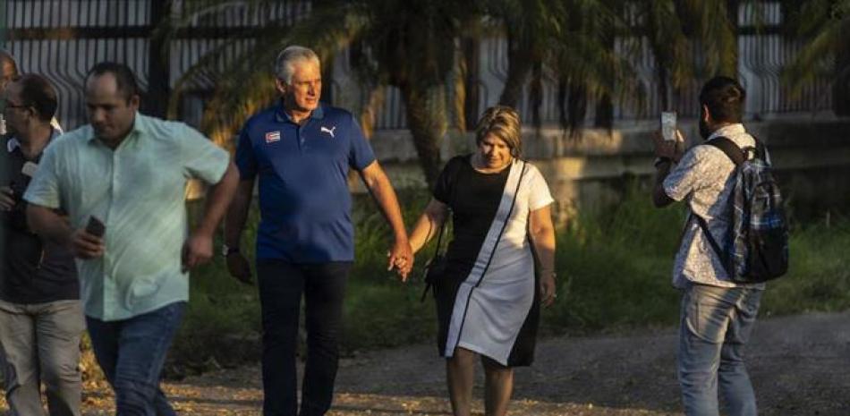El presidente de Cuba, Miguel Díaz-Canel, camina con su esposa Lis Cuesta Peraza antes de emitir su voto en un colegio electoral durante el referéndum . ap