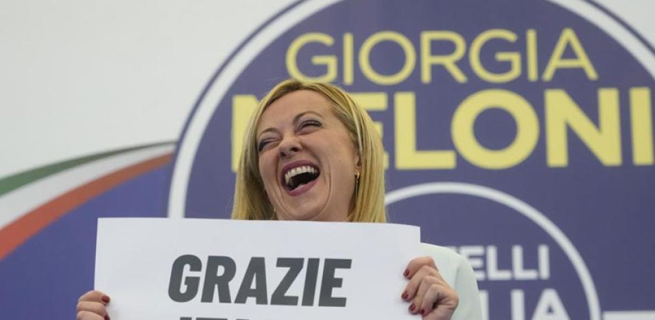 La líder del partido de extrema derecha Hermanos de Italia, Giorgia Meloni, muestra un cartel que dice en italiano “Gracias, Italia” en Roma, la madrugada de ayer. ap