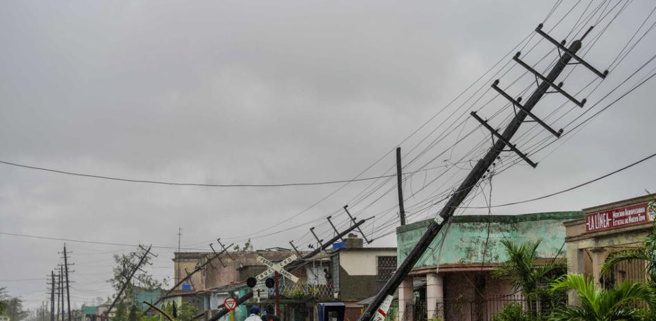 Postes de electricidad caídos y ramas caídas bordean una calle después de que el huracán Ian azotara Pinar del Río, Cuba. AP.