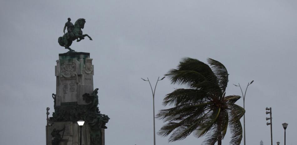 El viento sopla una palmera en el Monumento Antonio Maceo a lo largo del malecón durante el paso del huracán Ian en La Habana, Cuba, la madrugada del jueves 27 de septiembre de 2022.

Foto: AP/Ismael Francisco