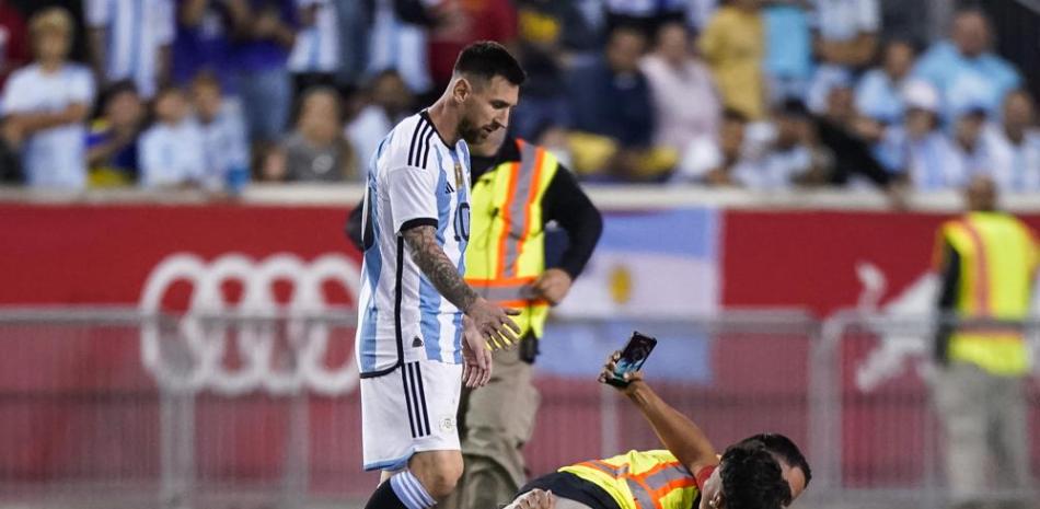 Un empleado de seguridad derriba a una persona que entró a la cancha con la intención de tomar una foto a Lionel Messi durante el partido amistoso entre Jamaica y Argentina.