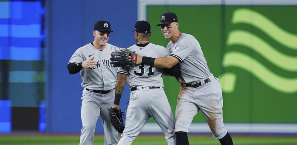 Aaron Judge y los demás dos jardienros de los Yankees festejan el triunfo ante los Azulejos.