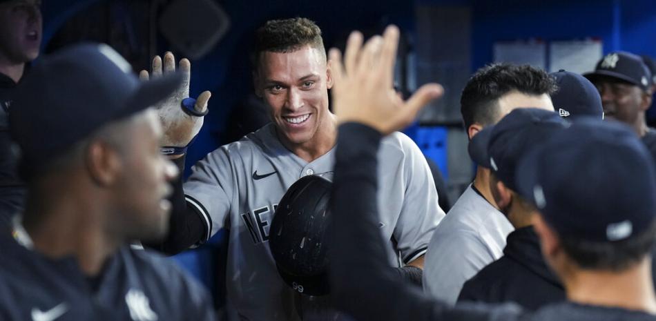 Aaron Judge, de los Yankees de Nueva York, sonríe en el banquillo luego de conectar su cuadrangular número 61 de la temporada, un jonrón de dos carreras, contra los Azulejos de Toronto durante la séptima entrada de un partido de béisbol el miércoles 28 de septiembre de 2022 en Toronto. (Nathan Denette/The Canadian Press vía AP)