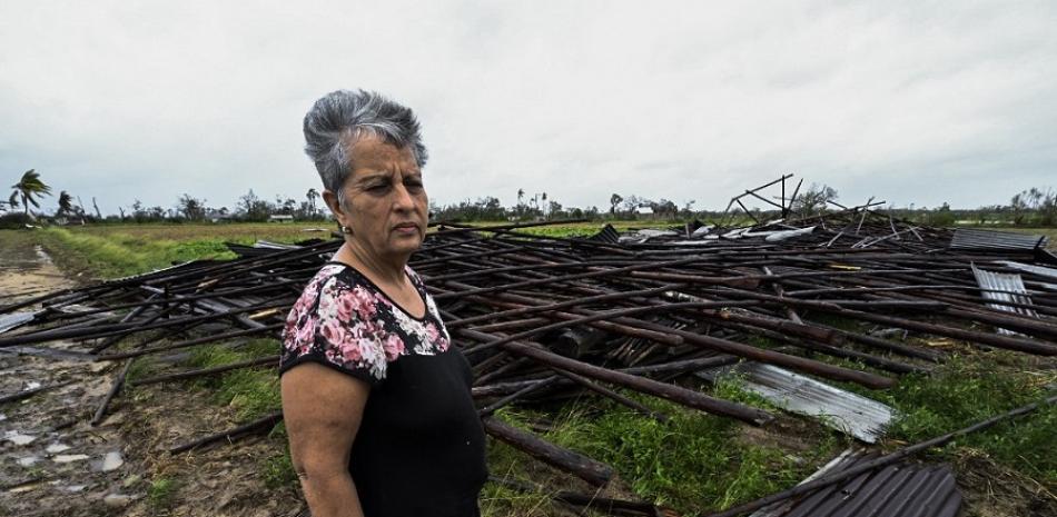 Maritza Carpio, propietaria de una finca de tabaco, mira su casa de tabaco destruida tras el paso del huracán Ian en San Juan y Martínez, provincia de Pinar del Río, Cuba. AFP.