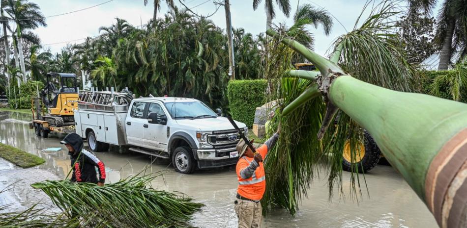 Trabajadores de la ciudad de Naples, Florida, limpian los escombros tras el paso del huracán Ian, el 29 de septiembre de 2022. El huracán Ian dejó gran parte de la costa suroeste de Florida en la oscuridad el jueves temprano, provocando inundaciones "catastróficas" que dejaron a los funcionarios preparando una enorme respuesta de emergencia a una tormenta de rara intensidad. El Centro Nacional de Huracanes dijo que el ojo del huracán "extremadamente peligroso" tocó tierra poco después de las 15:00 horas (19:00 GMT) en la isla barrera de Cayo Costa, al oeste de la ciudad de Fort Myers. Giorgio VIERA / AFP