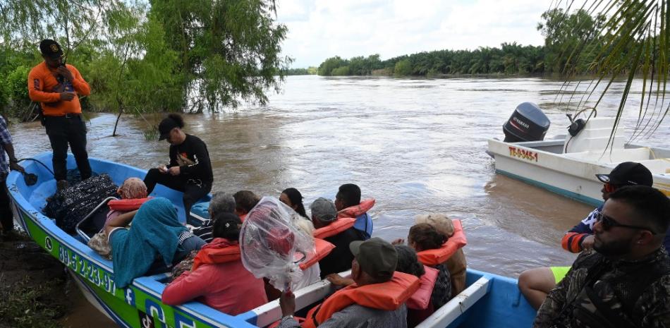 Voluntarios rescatan a habitantes de El Progreso, Honduras, tras desbordamiento del río Ulúa. AFP