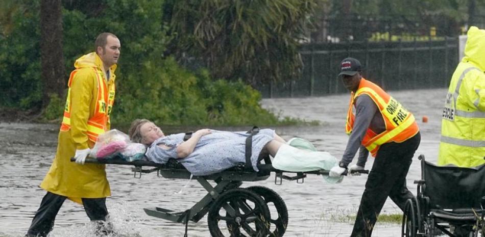 Dos hombres trasladan a una persona fuera del hogar de ancianos Avante después del paso del huracán Ian, ayer 29 de septiembre de 2022, en Orlando, Florida. ap