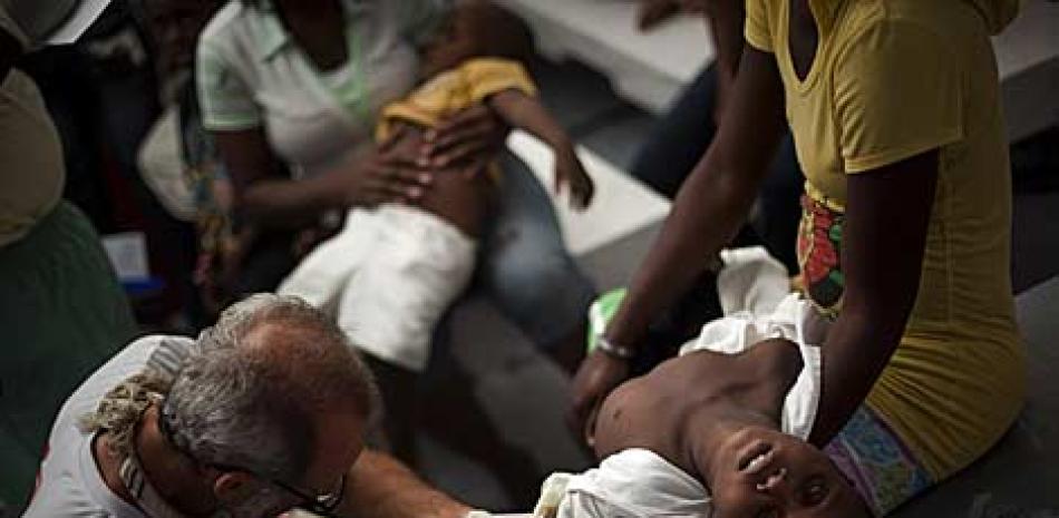 Un niño con síntomas de cólera es atendido por un médico en Puerto Príncipe. AP