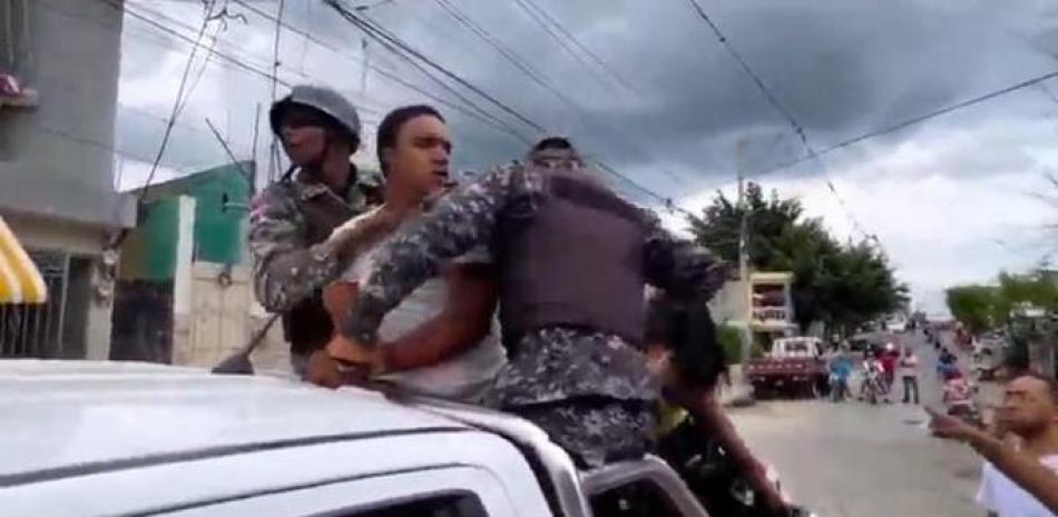 Momento en que los policías apresan al joven de la comunidad Los Salados. Captura de video.