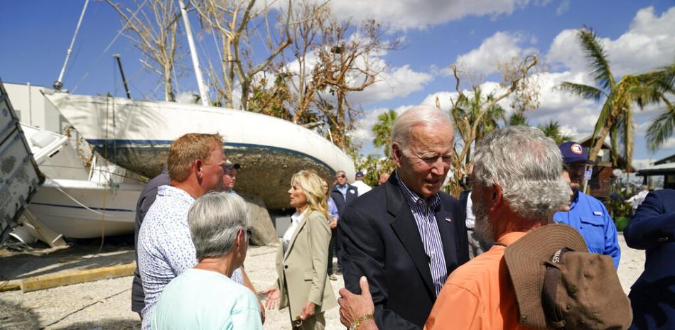 El presidente Joe Biden y la primera dama Jill Biden hablan con las personas afectadas por el huracán Ian durante un recorrido por la zona. AP.
