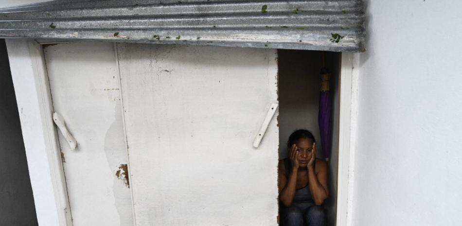 Caridad Álvarez, trabajadora de una empresa tabacalera, muestra el lugar donde se escondió durante el paso del huracán Ian, que destruyó su casa en San Juan y Martínez, provincia de Pinar del Río, Cuba, el 27 de septiembre de 2022.

Foto: ADALBERTO ROQUE / AFP