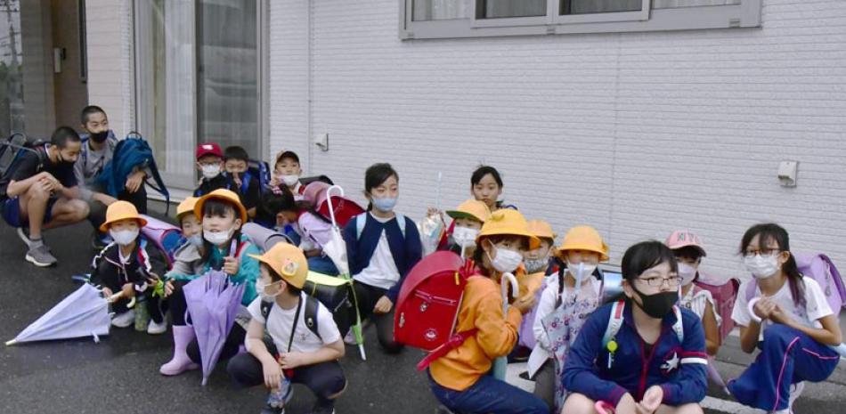 Estudiantes japoneses se refugian en un edificio de regreso a casa, tras el lanzamiento de Norcorea. ap