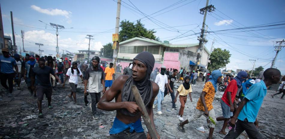 Un manifestante porta un pedazo de madera que finge es un rifle durante una protesta antigubernamental en Puerto Príncipe el 3 de octubre del 2022.  ap