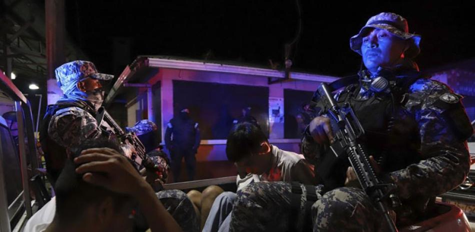 Fuerzas de la Policía Nacional Civil transportan a detenidos por vínculos con las pandillas.  ap