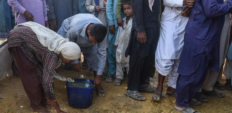 En esta imagen tomada el 26 de septiembre de 2022, los desplazados internos afectados por las inundaciones llenan de agua potable de un charco fuera de un campamento improvisado en el distrito de Jamshoro de la provincia de Sindh.

Foto: Rizwan Tabaso| AFP