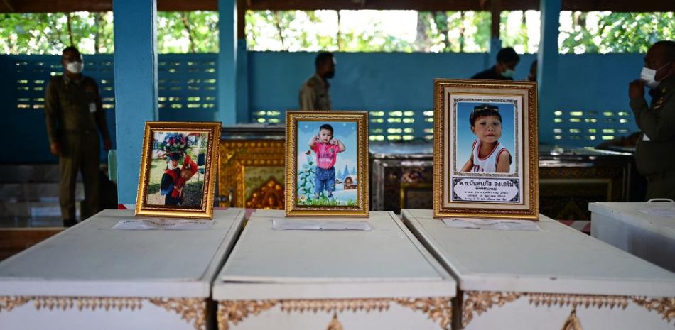 Los retratos de las jóvenes víctimas de un tiroteo masivo en una guardería se muestran sobre sus ataúdes mientras se realizan los preparativos del funeral en el templo Wat Si Uthai en la provincia nororiental de Nong Bua Lam Phu, Tailandia, el 7 de octubre de 2022.
Foto: MANAN VATSYAYANA / AFP