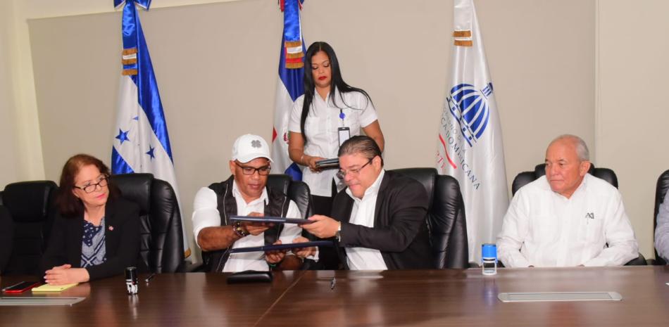 El ministro de Deportes de República Dominicana, Francisco Camacho, y su homólogo de Honduras, Mario Moncada, estrechan sus manos, luego del pacto suscrito este viernes.