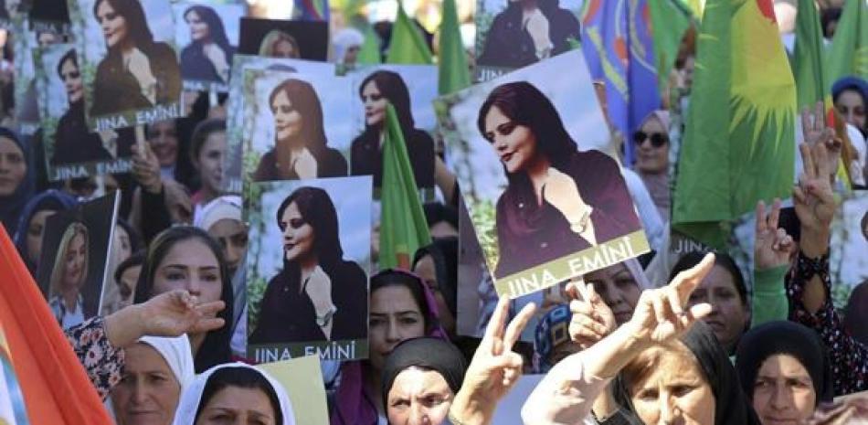 Mujeres kurdas llevan retratos de la iraní Mahsa Amini en una protesta por su asesinato en Irán, en Qamishli el 26 de septiembre del 2022. ap