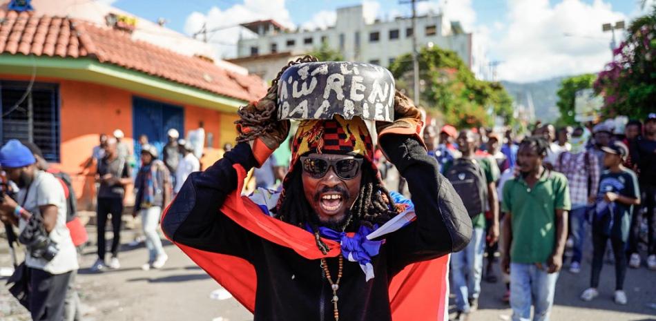 Un manifestante canta durante una manifestación para exigir la renuncia del primer Ariel Henry y en contra de la Carta en Puerto Príncipe el 29 de septiembre de 2022. Los funcionarios describieron una "catástrofe humanitaria" en Haití ante el Consejo de Seguridad de la ONU el 26 de septiembre de 2022, como la nación alcanza "nuevos niveles de desesperación" después de dos semanas de violencia y ataques a almacenes de ayuda alimentaria. Las protestas y los saqueos han sacudido al ya inestable país desde el 11 de septiembre, cuando el primer ministro Ariel Henry anunció un aumento en el precio del combustible; dice que los subsidios son demasiado caros para uno de los estados más pobres del mundo. Richard Pierrin / AFP