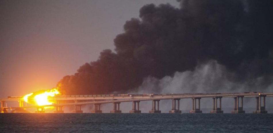 Llamas y humo se elevan de un puente que conecta la península de Crimea con territorio continental ruso sobre el Estrecho de Kerch, el sábado 8 de octubre de 2022, en Kerch, Crimea. ap