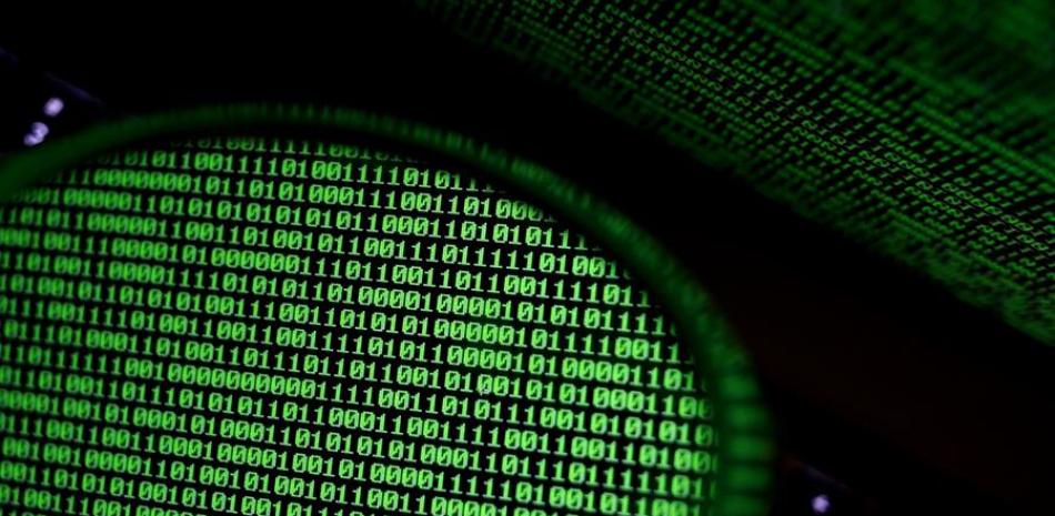 Un espejo refleja una pantalla de ordenador que muestra un código binario, en una fotografía de archivo. EFE/RITCHIE B. TONGO