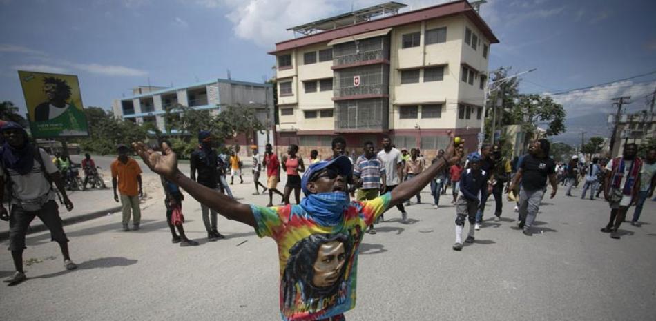 Un manifestante reza de rodillas durante una protesta para exigir la renuncia del primer ministro Ariel Henry en el área de Petion-Ville de Puerto Príncipe, el lunes 3 de octubre de 2022. AP