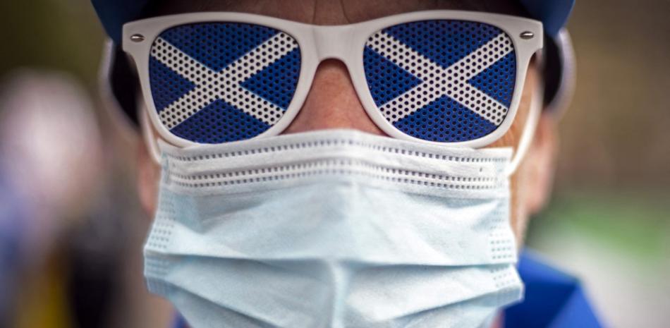 En esta foto de archivo tomada el 1 de mayo de 2021, un manifestante a favor de la independencia que se cubre la cara para combatir la propagación del coronavirus se une a una reunión en George Square, Glasgow, antes de las próximas elecciones al Parlamento escocés que se llevarán a cabo el 6 de mayo de 2021.
Andy Buchanan / AFP