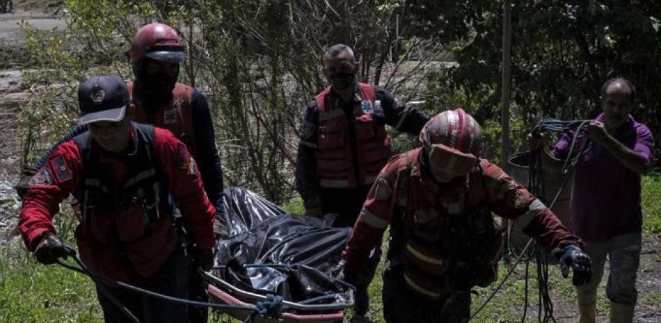 Rescatistas de diferentes instituciones de extinción de incendios y de la Cruz Roja trasladan uno de los dos cadáveres recuperados a orillas del río Tuy días después de un devastador deslizamiento de tierra en la localidad venezolana de Las Tejerías el 11 de octubre de 2022. Las esperanzas se desvanecían el martes de encontrar con vida a alguno de los más de 50 personas desaparecidas tras un devastador deslizamiento de tierra arrasó una ciudad venezolana con 43 muertos confirmados hasta la fecha. El presidente Nicolás Maduro dijo en la televisión estatal que se espera que el número de muertos llegue a 100. Yuri CORTEZ / AFP