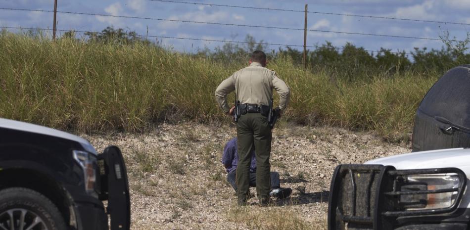Un oficial del alguacil del condado de Webb y la Patrulla Fronteriza de EE. UU. arrestan a un hombre que traficaba migrantes en un vehículo el 12 de octubre de 2022 en Laredo, Texas. Allison Dinner / AFP