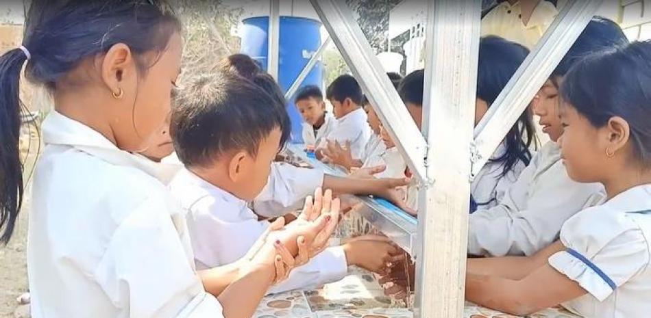 Alumnos de la escuela de Broylatngor, en Camboya, se lavan las manos en el lavabo comunitario construido gracias a la colaboración entre AUARA y la organización Karuna Battambang. - AUARA