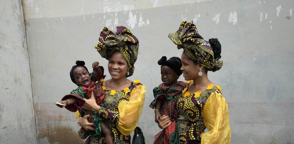 Los mellizos Oladapo Taiwo, a la izquierda, y Oladapo Kehinde, de 21 años, posan para fotografías con los mellizos de un pariente durante el festival anual de mellizos en Igbo-Ora, suroeste de Nigeria, el sábado 8 de octubre de 2022. (Foto AP/Sunday Alamba)