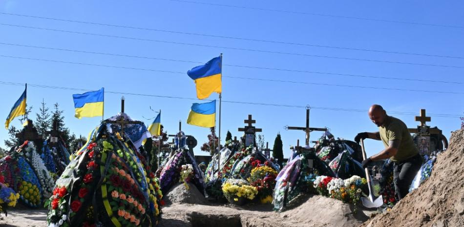 Un trabajador comunal llena una tumba de Oleksiy Telyzhenko, de 44 años, cuyo cuerpo ha estado desaparecido desde su captura en el asalto abortado de Rusia a Kyiv en las primeras semanas de la invasión rusa en marzo de 2022, después de su ceremonia fúnebre en el suburbio de Bucha en Kyiv.

Foto: Serguéi Supinsky| AFP
