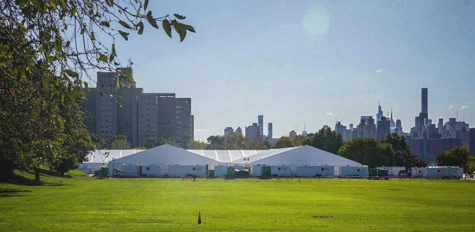 El Centro Humanitario de Ayuda y Respuesta de Emergencia de Randall, un complejo de grandes carpas que la ciudad de Nueva York empleará como refugio temporal para migrantes internacionales enviados en autobús por estados fronterizos sureños, el martes 18 de octubre de 2022, en Nueva York. El refugio empezará a recibir a hombres adultos que hayan llegado solos el miércoles 19 de octubre. (AP Foto/Bebeto Matthews)