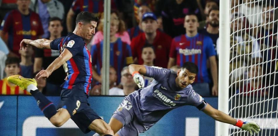 Robert Lewandowski, del Barcelona, a la izquierda, anota el primer gol del partido frente al portero del Villarreal Geronimo Rulli en el partido de la Liga Española.