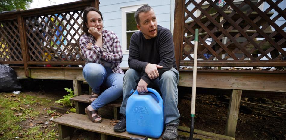Lucinda Tyler y Aaron Raymo fuera de su casa con los contenedores que usaron para llenar su tanque de combustible para calefacción en su casa, el miércoles 5 de octubre de 2022 en Jay, Maine.

Foto: AP Foto/Robert F. Bukaty