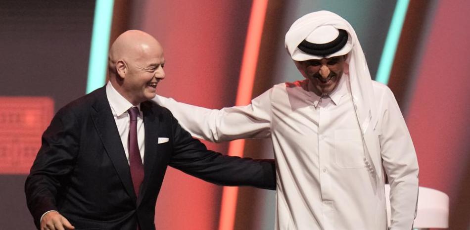 El presidente de la FIFA Gianni Infantino (izquierda) y el emir de Qatar Tamim bin Hamad Al Thani se retiran del escenario previo al sorteo de la Copa Mundial.