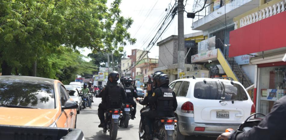 Unidades motorizadas de la Policía recorren una vía del poblado sector Villa Mella.