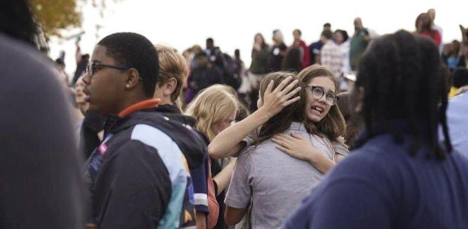 Unas personas se reúnen afuera de una escuela secundaria de San Luis, Missouri, luego de que se registró un tiroteo, el lunes 24 de octubre de 2022. (Jordan Opp/St. Louis Post-Dispatch via AP)
